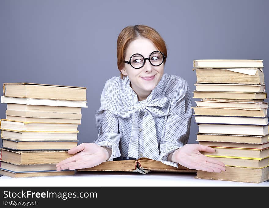 The young teacher in glasses with books. Studio shot.