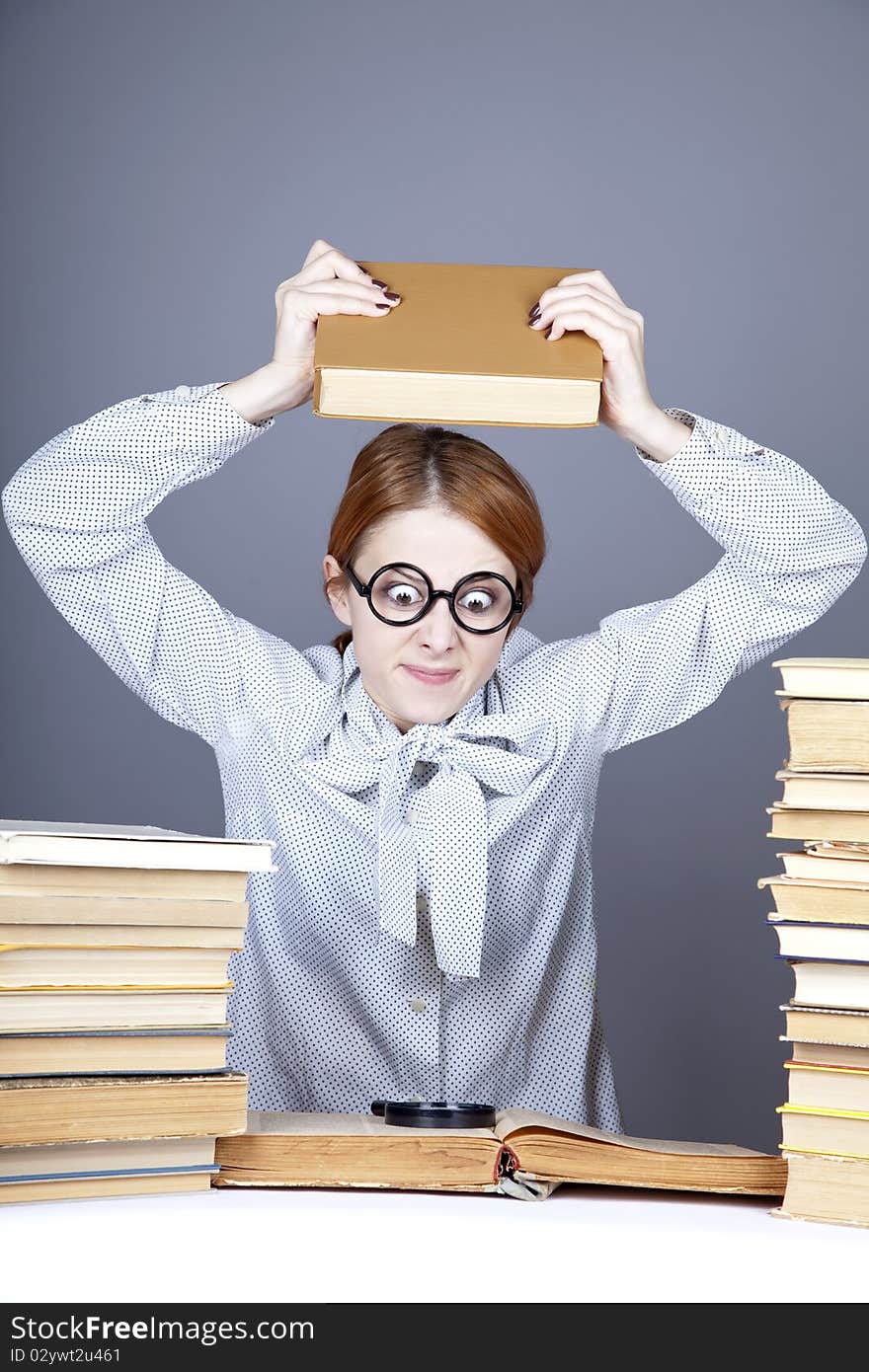 The young teacher in glasses with books.