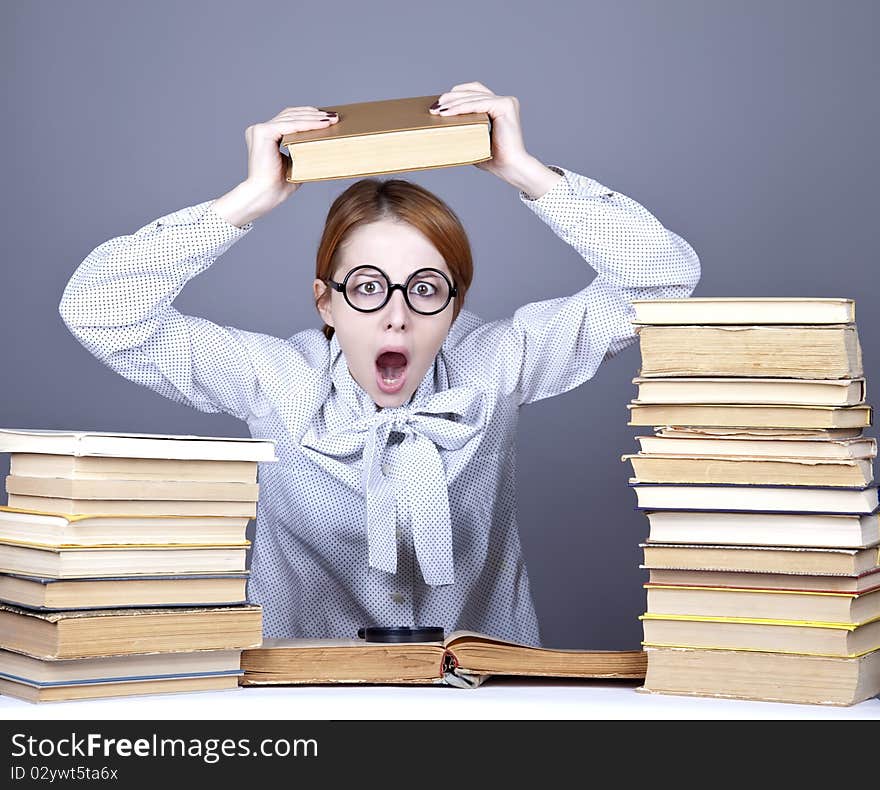 The young teacher in glasses with books. Studio shot.