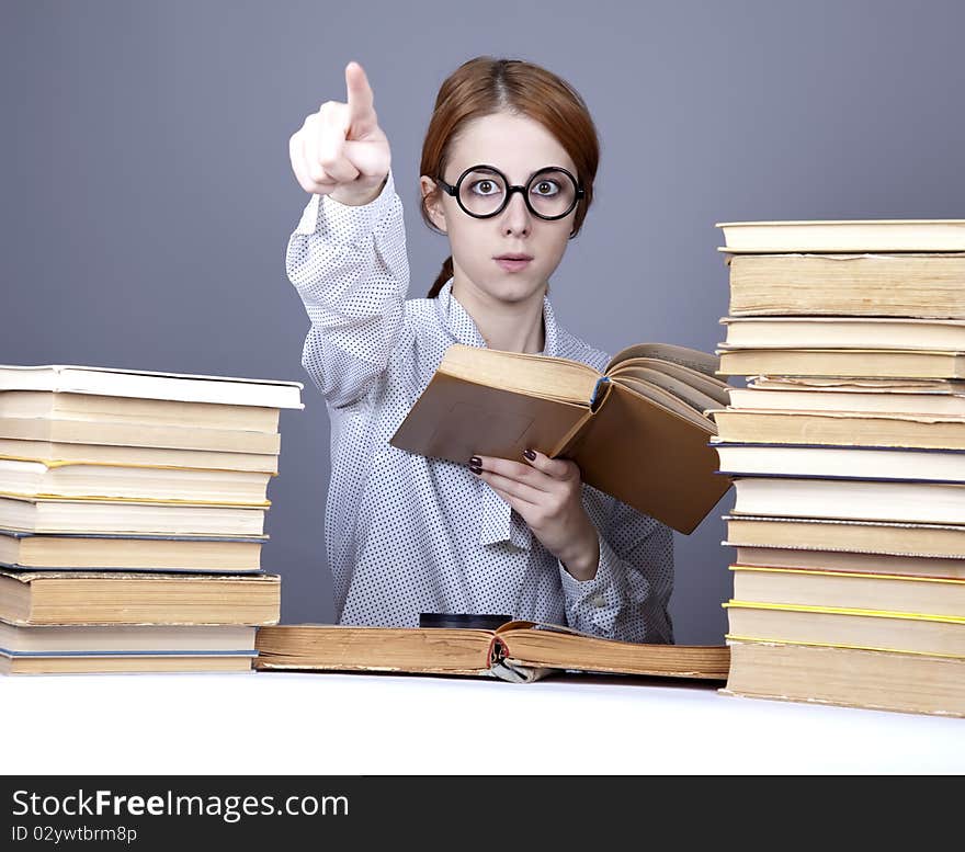 The young teacher in glasses with books. Studio shot.