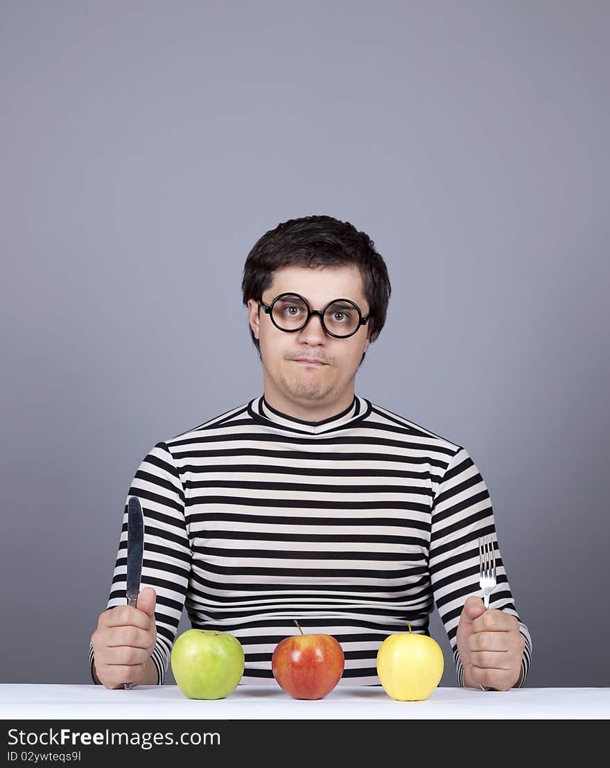 Funny boy try to eat apples. Studio shot.