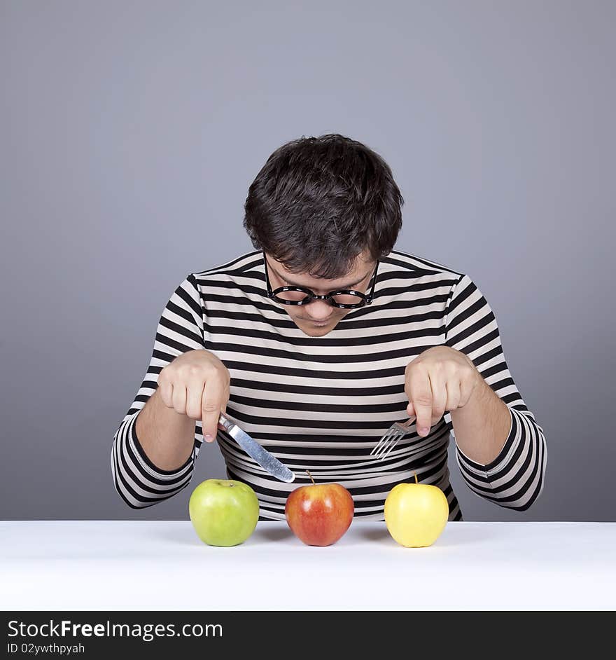 Funny boy try to eat apples. Studio shot.