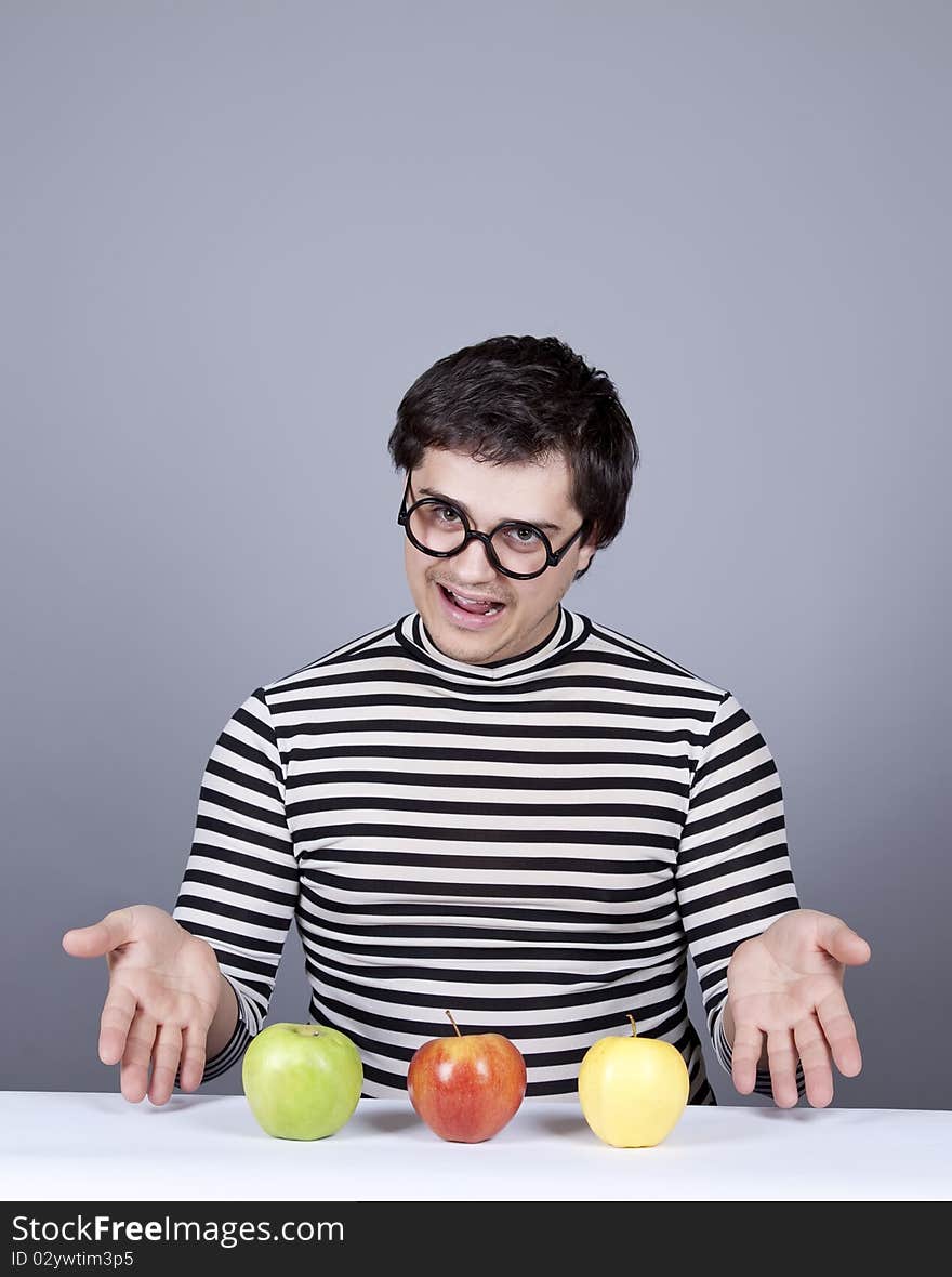 Funny boy try to eat apples. Studio shot.