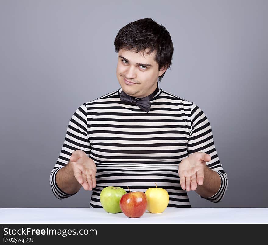 Funny boy try to eat apples. Studio shot.