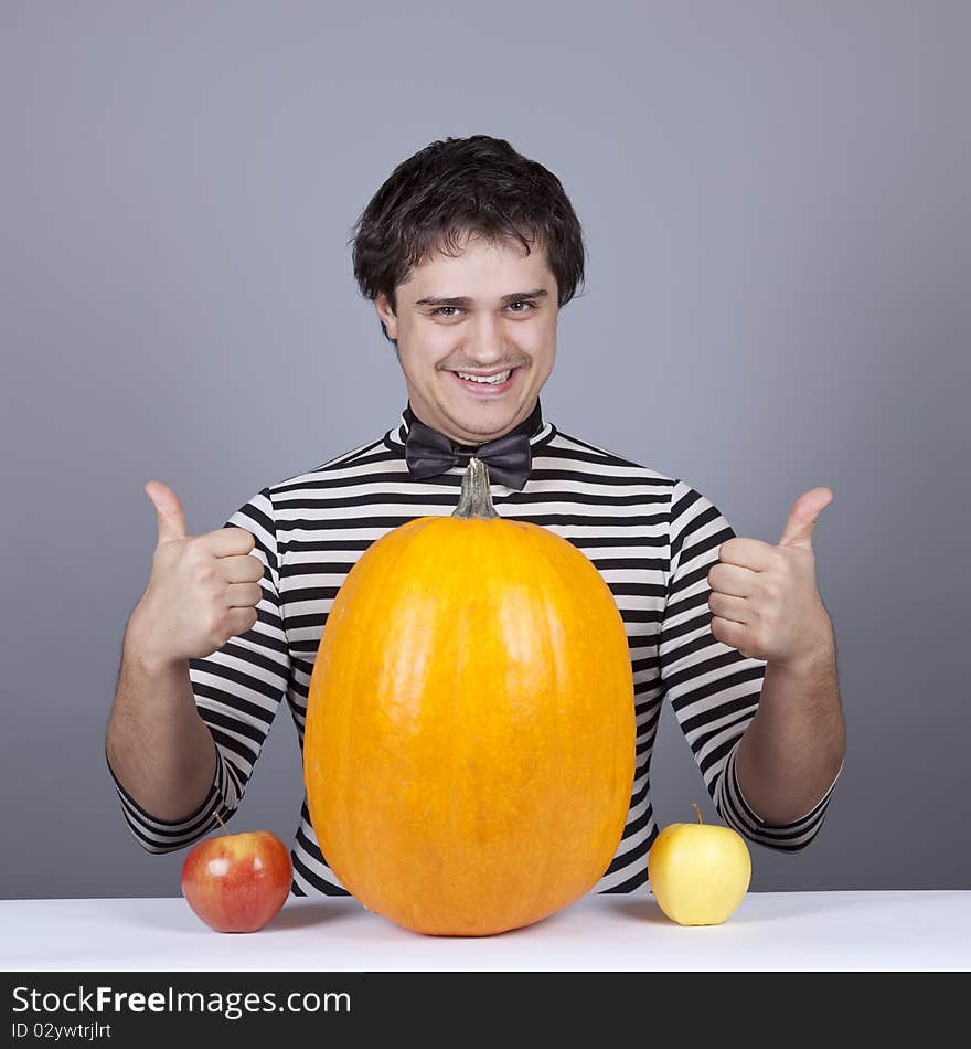 Funny men with two apples and one pumpkin. Studio shot.