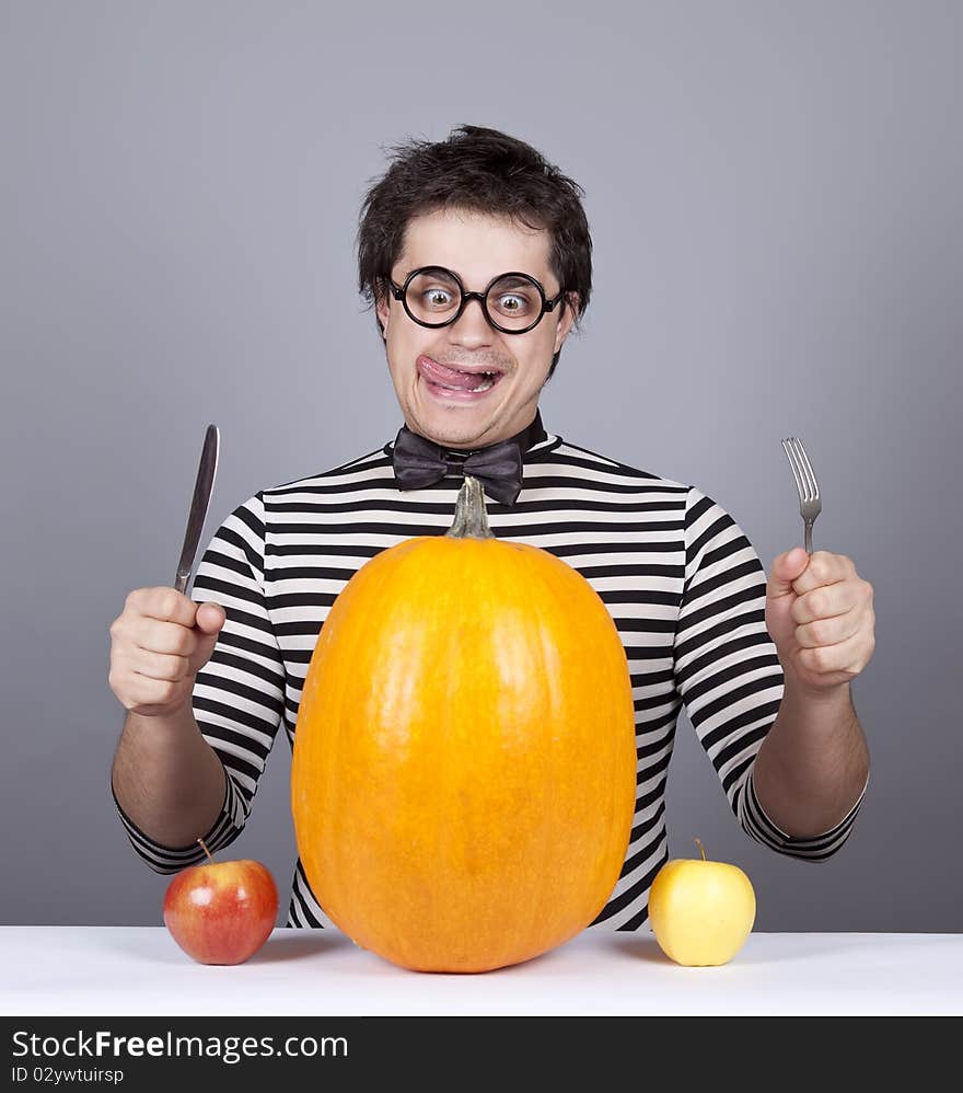 The young mad men try to eat apples and pumpkin.