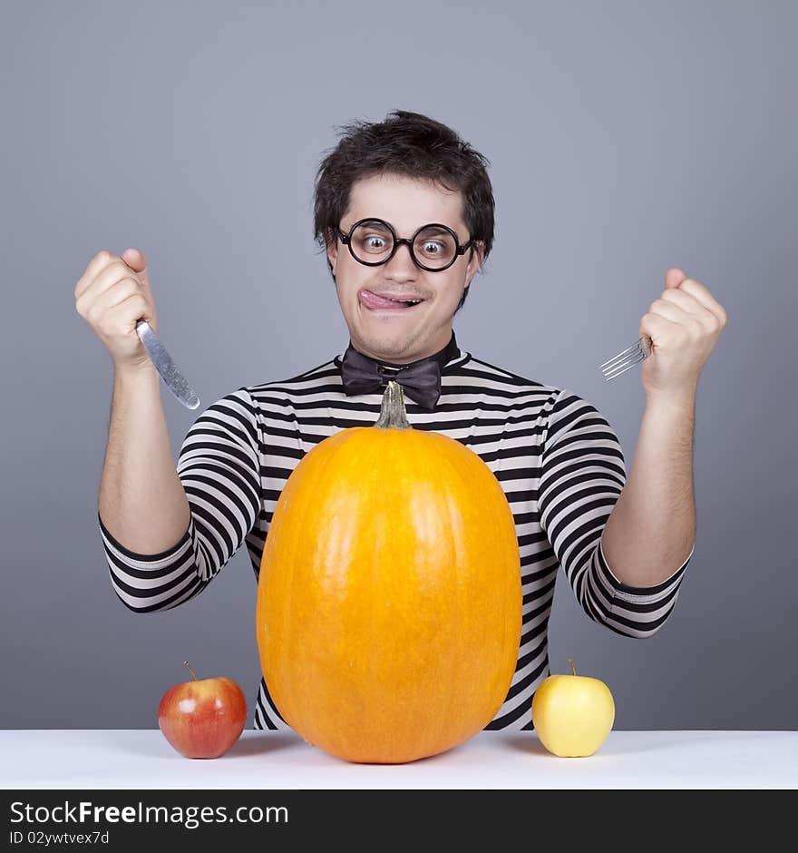 The young mad men try to eat apples and pumpkin.