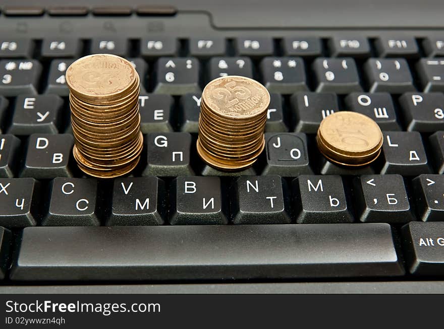 Stacks of coins on a black computer keyboard