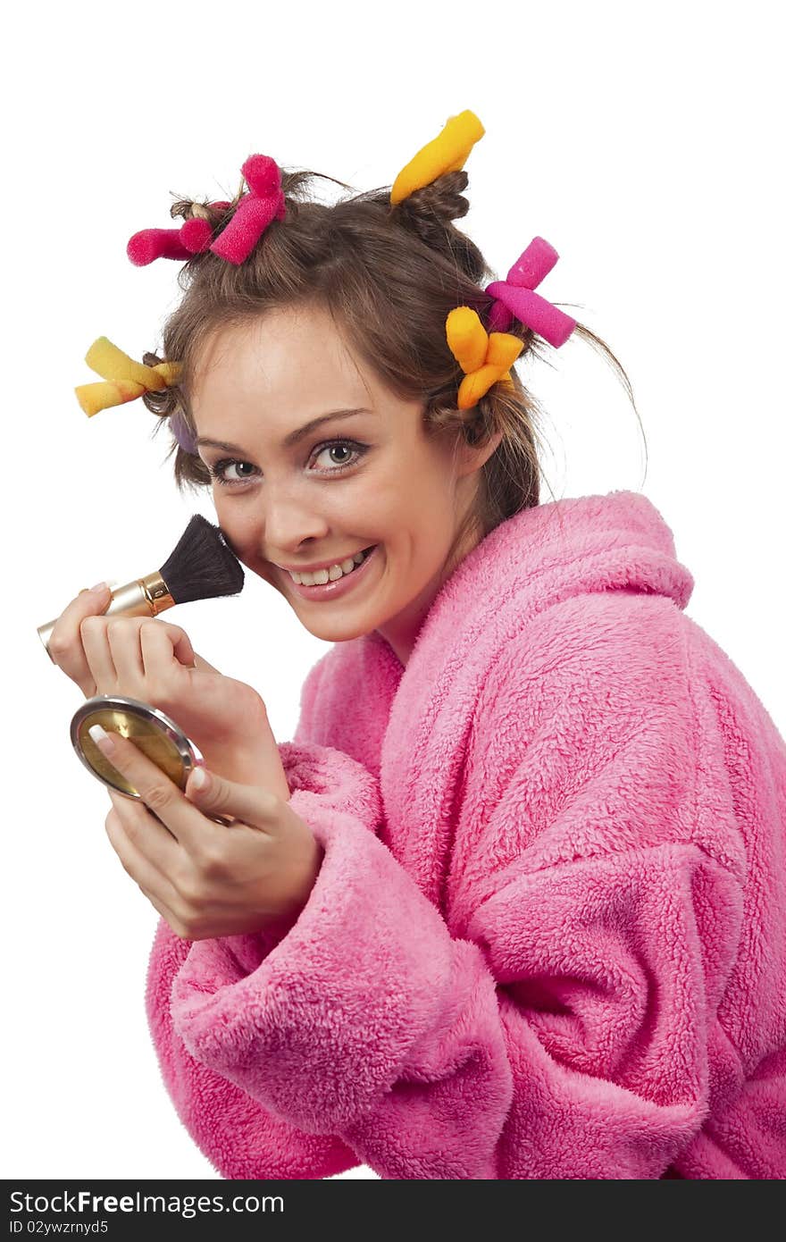 Portrait of beautiful woman in pink bath robe making-up, on white background