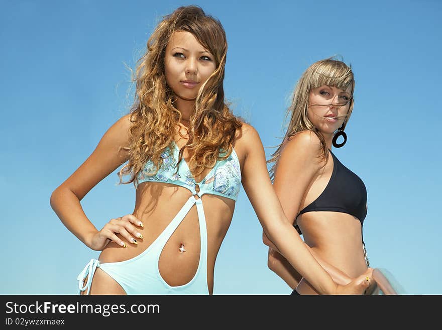 Two beautiful bikini model against blue sky