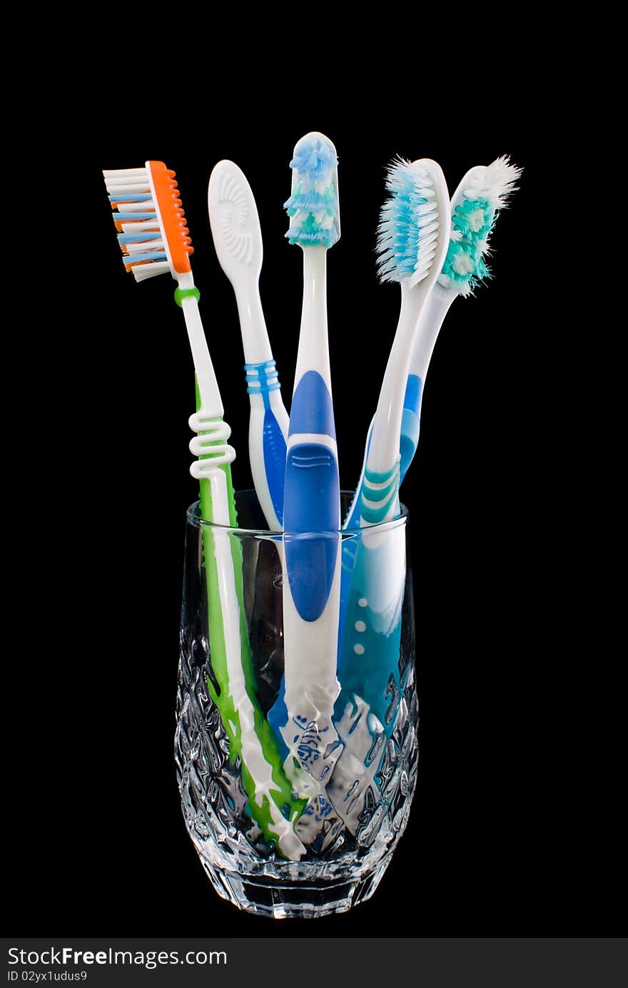 Toothbrush standing in a glass on a black background