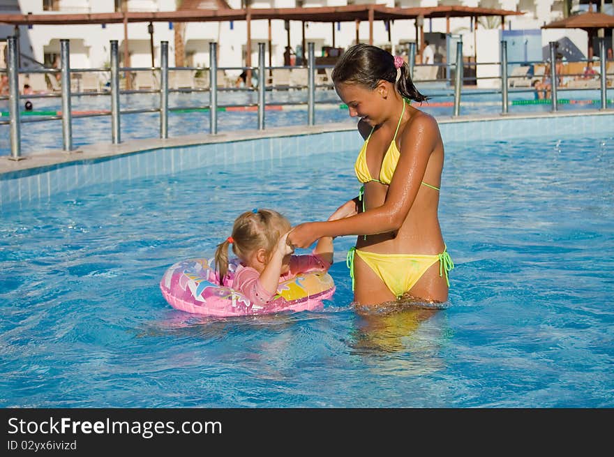 Two Girls Float In Pool