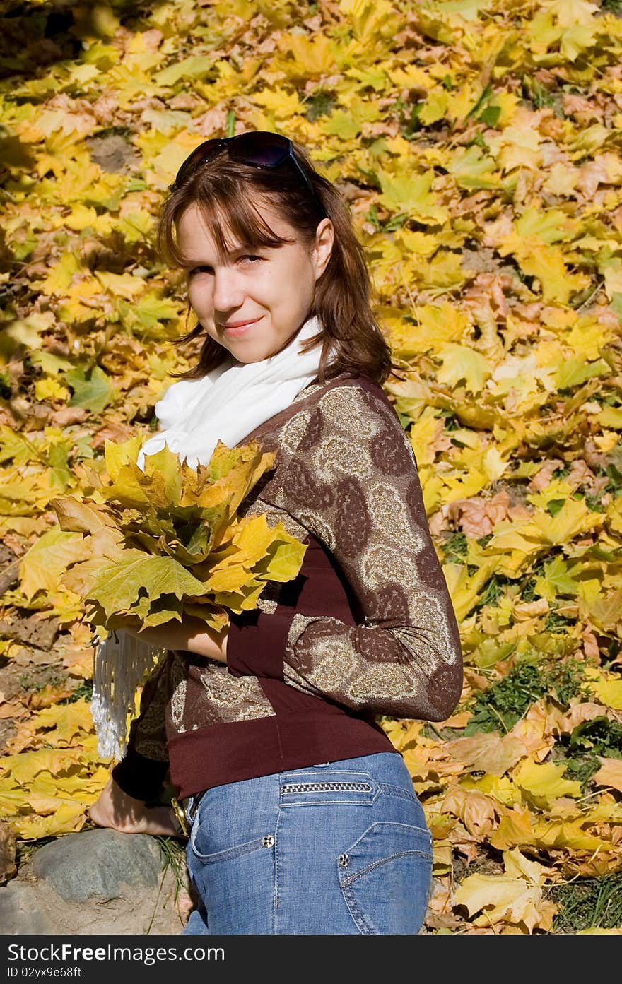 The beautiful girl with autumn leaves outdoor