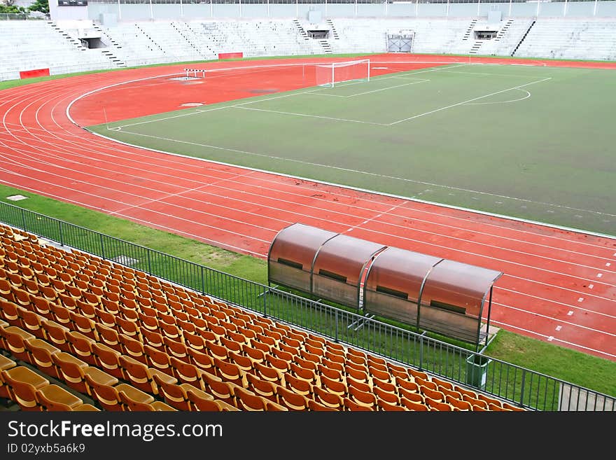 Landscape of Coach and reserve benches with yellow seats in football stadium