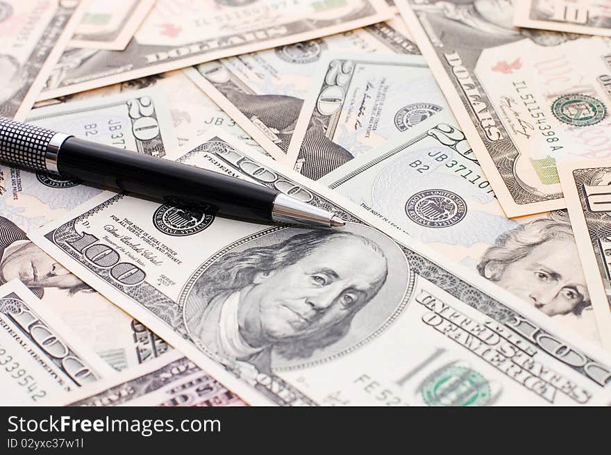 Dollar banknotes and pen