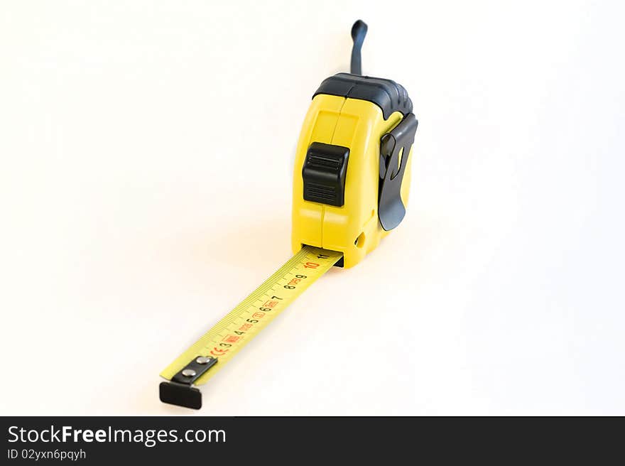 Yellow plastic tape measure on a white background close-up