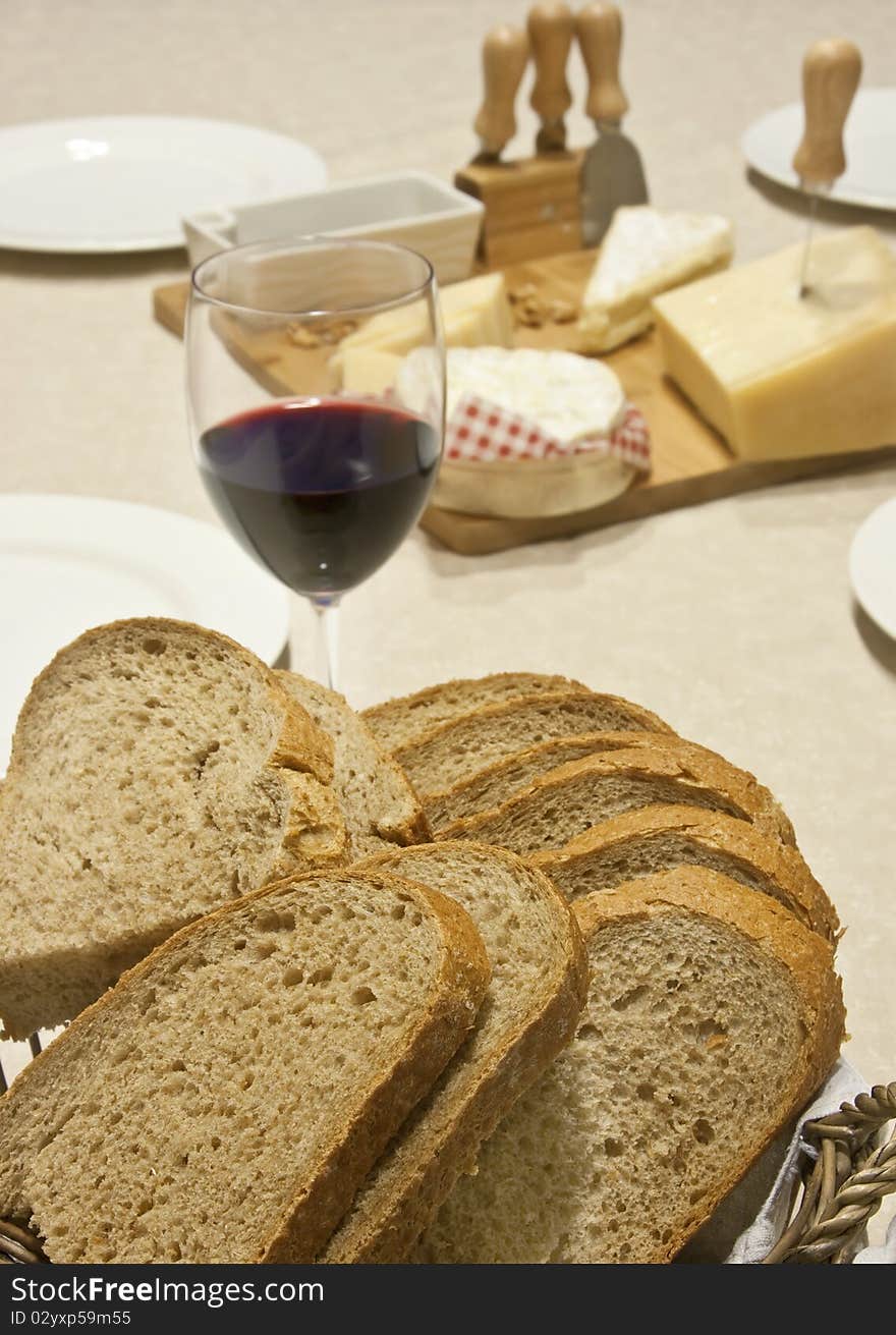 Slices of fresh bread with a glass of wine and cheese behind. Slices of fresh bread with a glass of wine and cheese behind