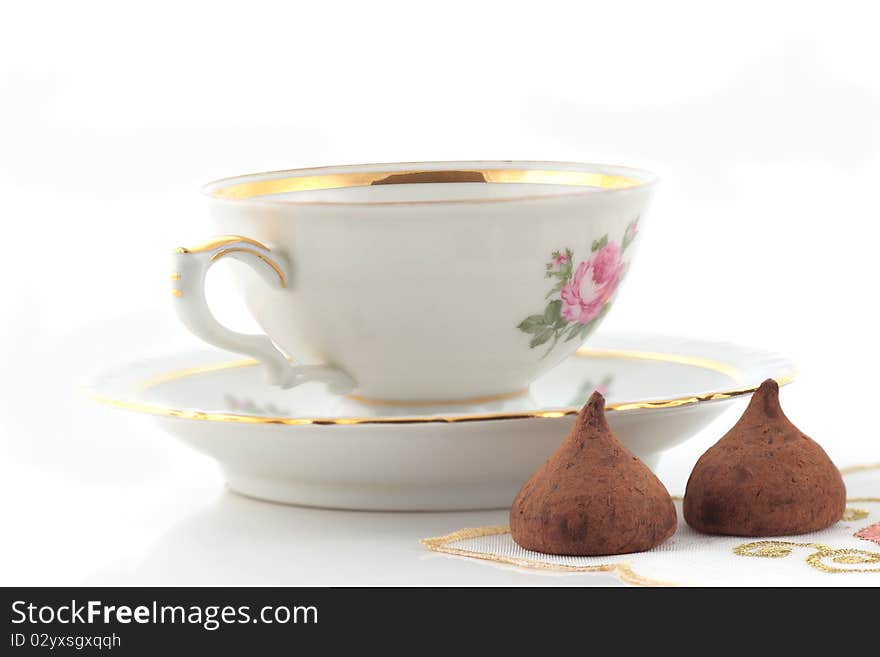 Tea cup and chocolates on a white background