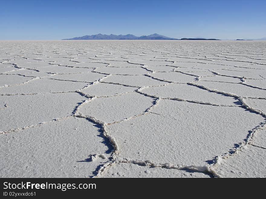 Patterns in the salt of Tunupa salt flats, with volcanic hills in the background