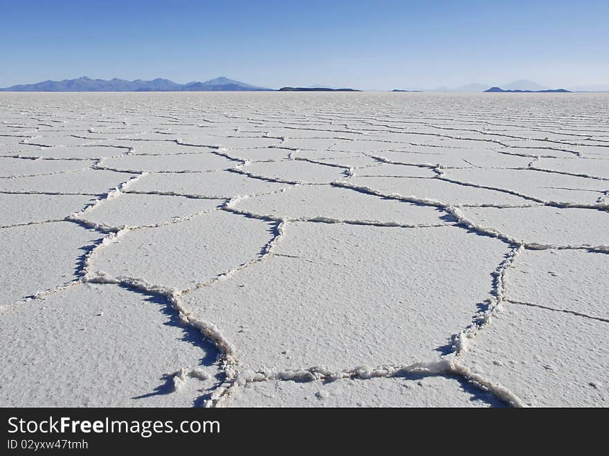 Patterns in the salt of Tunupa salt flats, with volcanic hills in the background