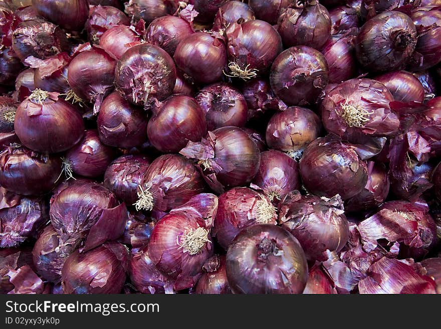 Red onions in a plile at a farm stand