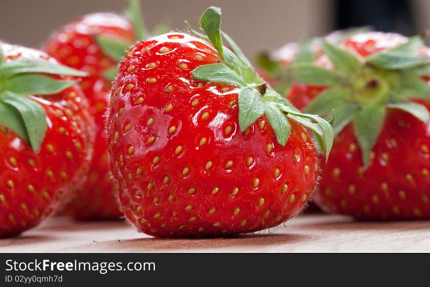 Strawberry with green leaf on the wood texture