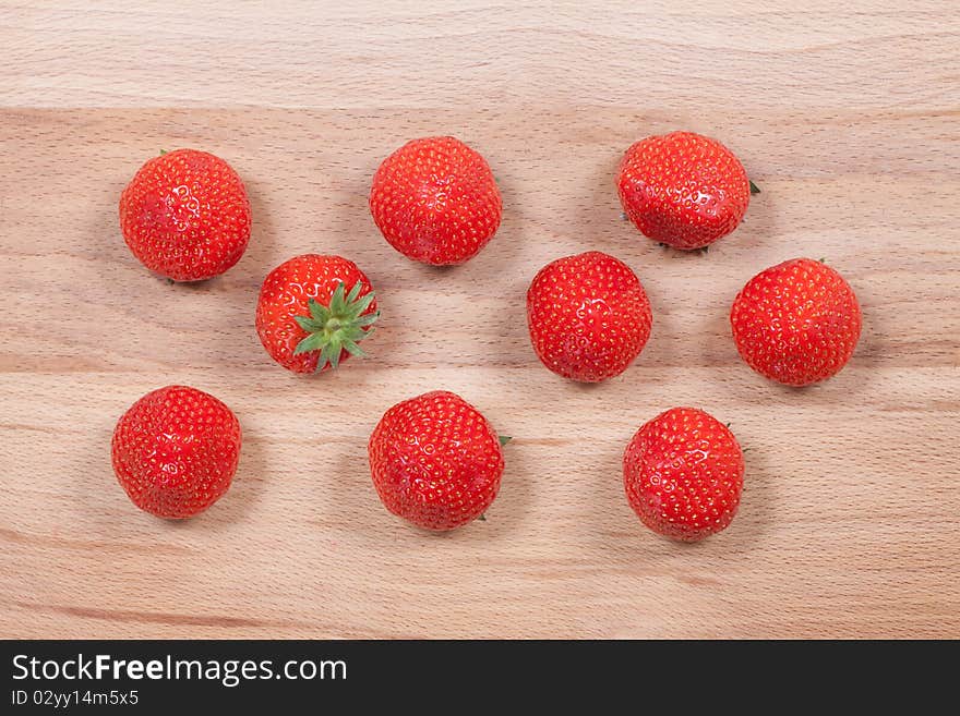 Strawberry with green leaf on the wood texture