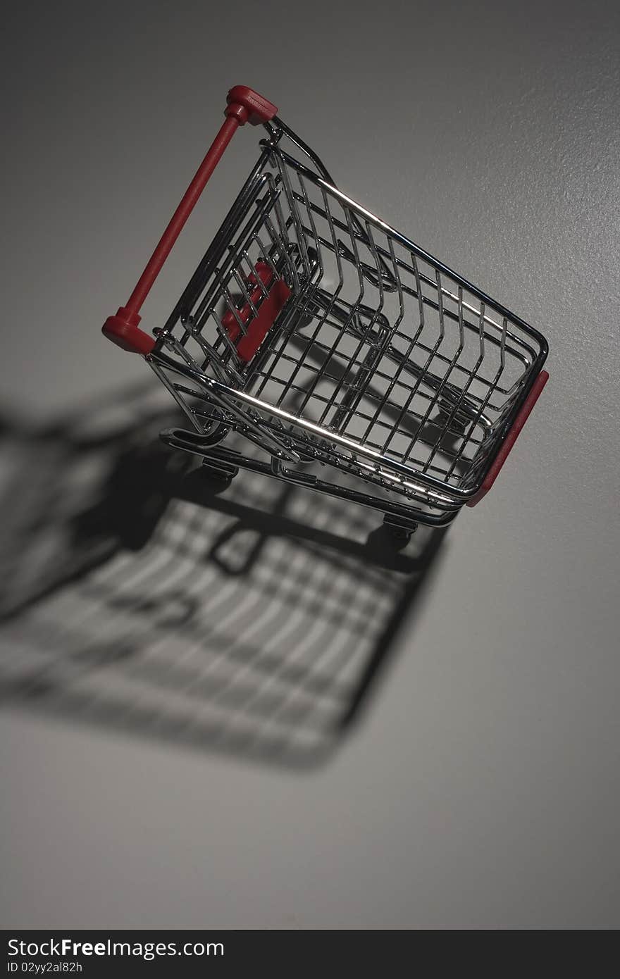 Shade from empty shopping cart with the red handle.