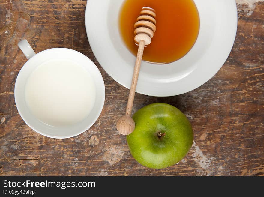 Breakfast with milk, honey and apple on the old wooden table