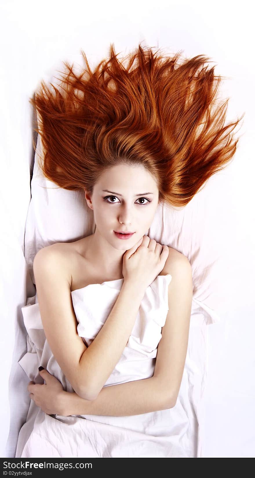 Woman in white nightie lying in the bed.