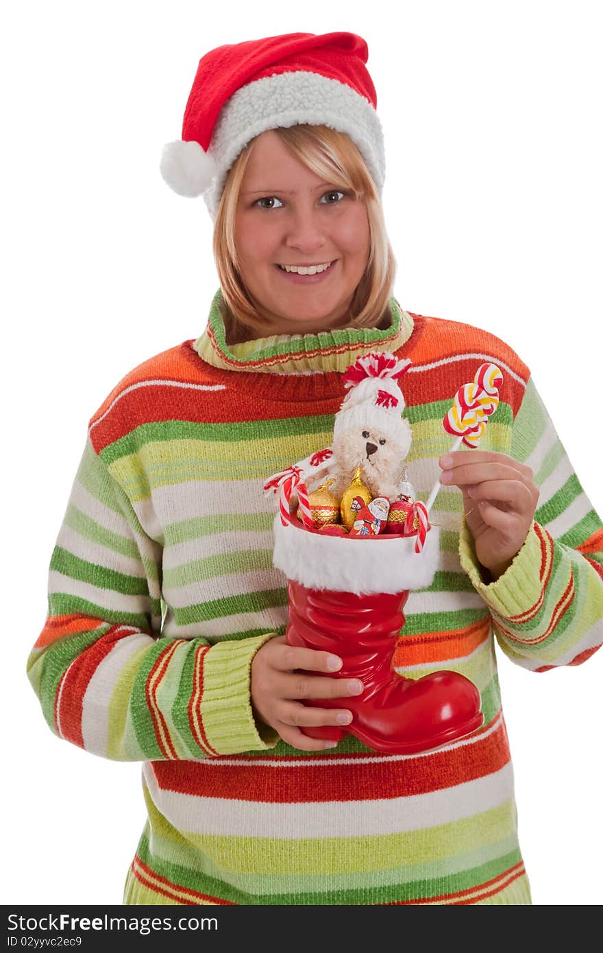 Young woman with santa hat holding a red boot full of sweets - isolated. Young woman with santa hat holding a red boot full of sweets - isolated