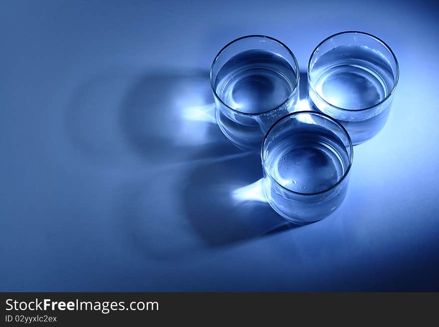 Three glasses of water in a blue background