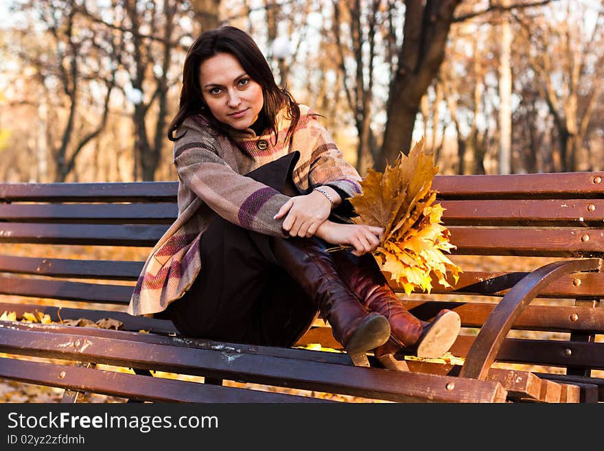 Beautiful young woman on a bench in autumn. Beautiful young woman on a bench in autumn