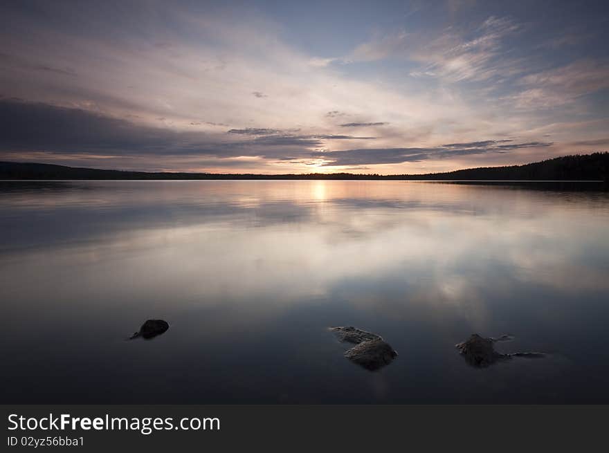 A calm lake. The clouds are reflecting on the surface.