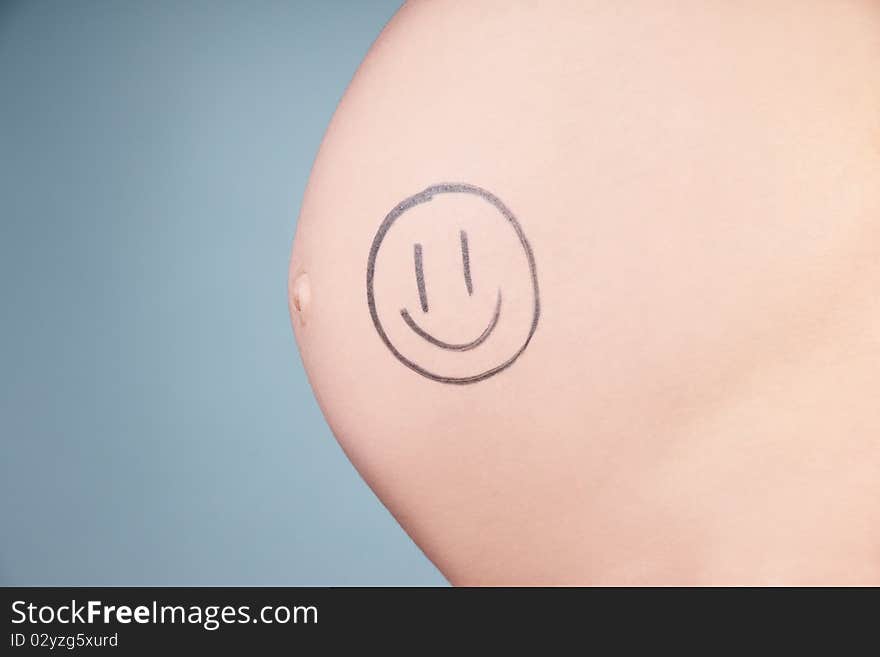 Tummy of pregnant woman with little drawing, studio shot