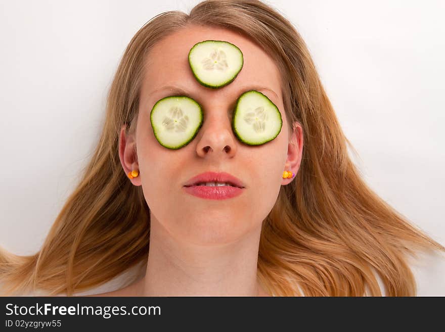 A young woman with a cucumber face mask