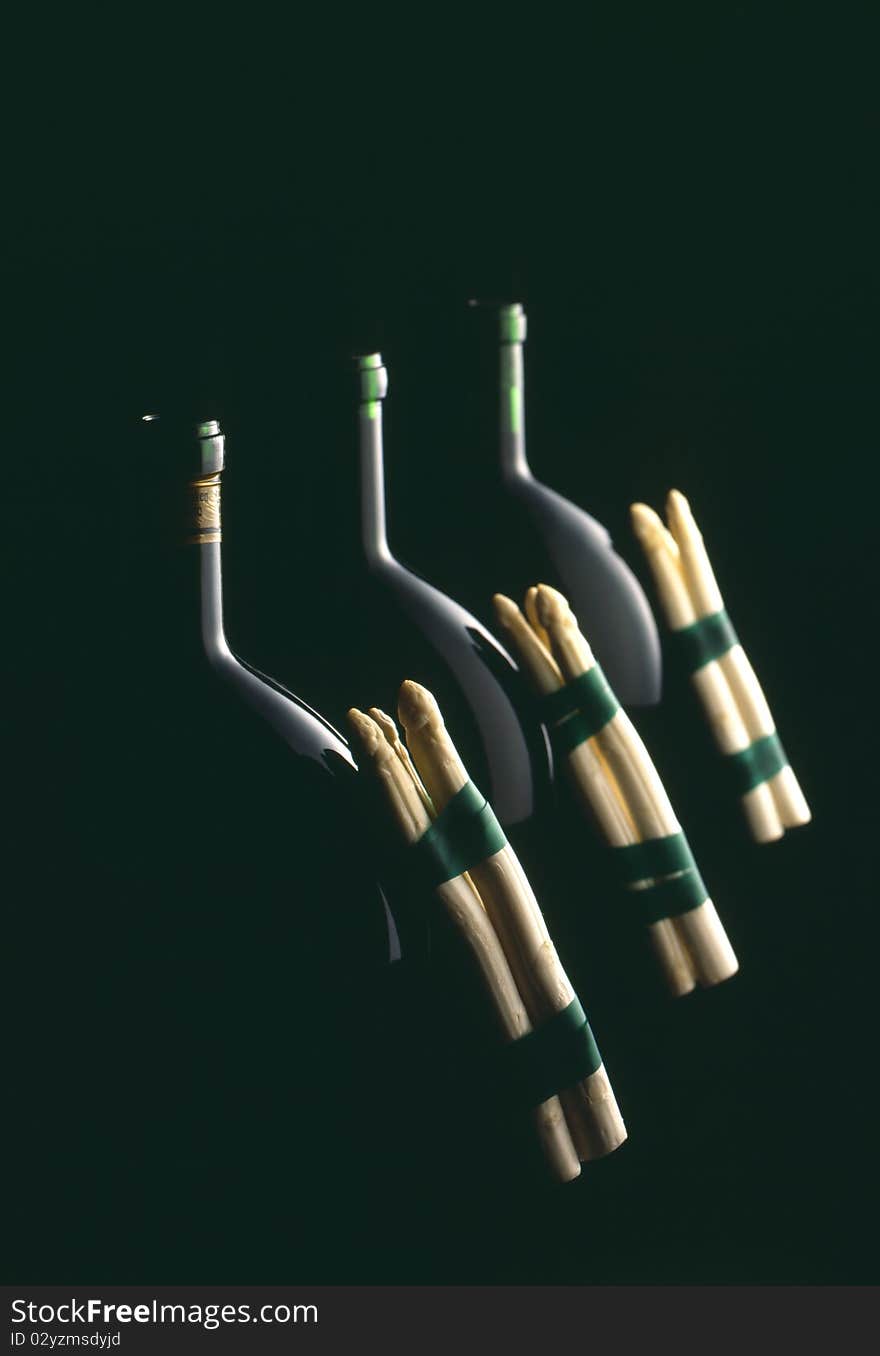 Bottle of wine with asparagus and black background