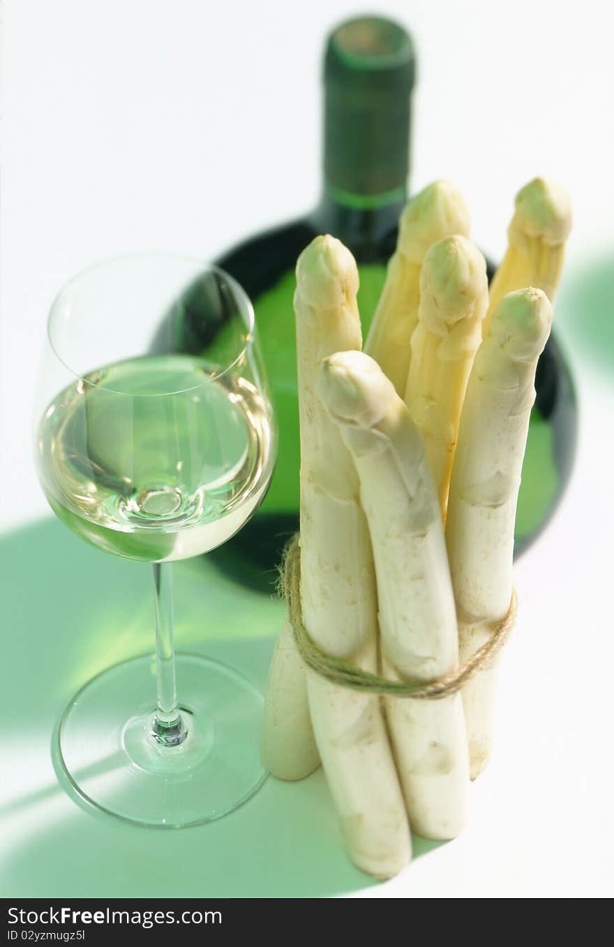 Glass and bottle of white wine with asparagus