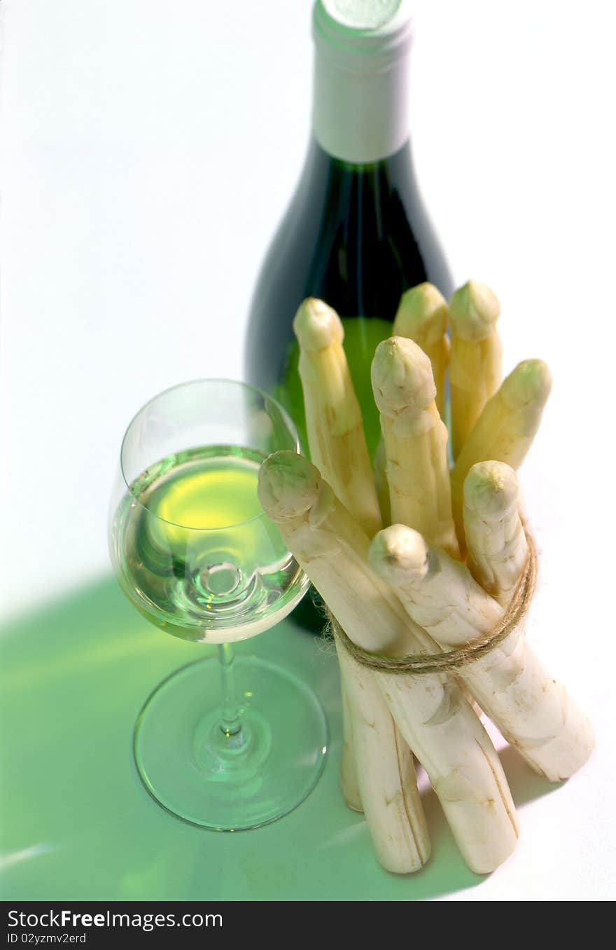 Glass and bottle of white wine with asparagus