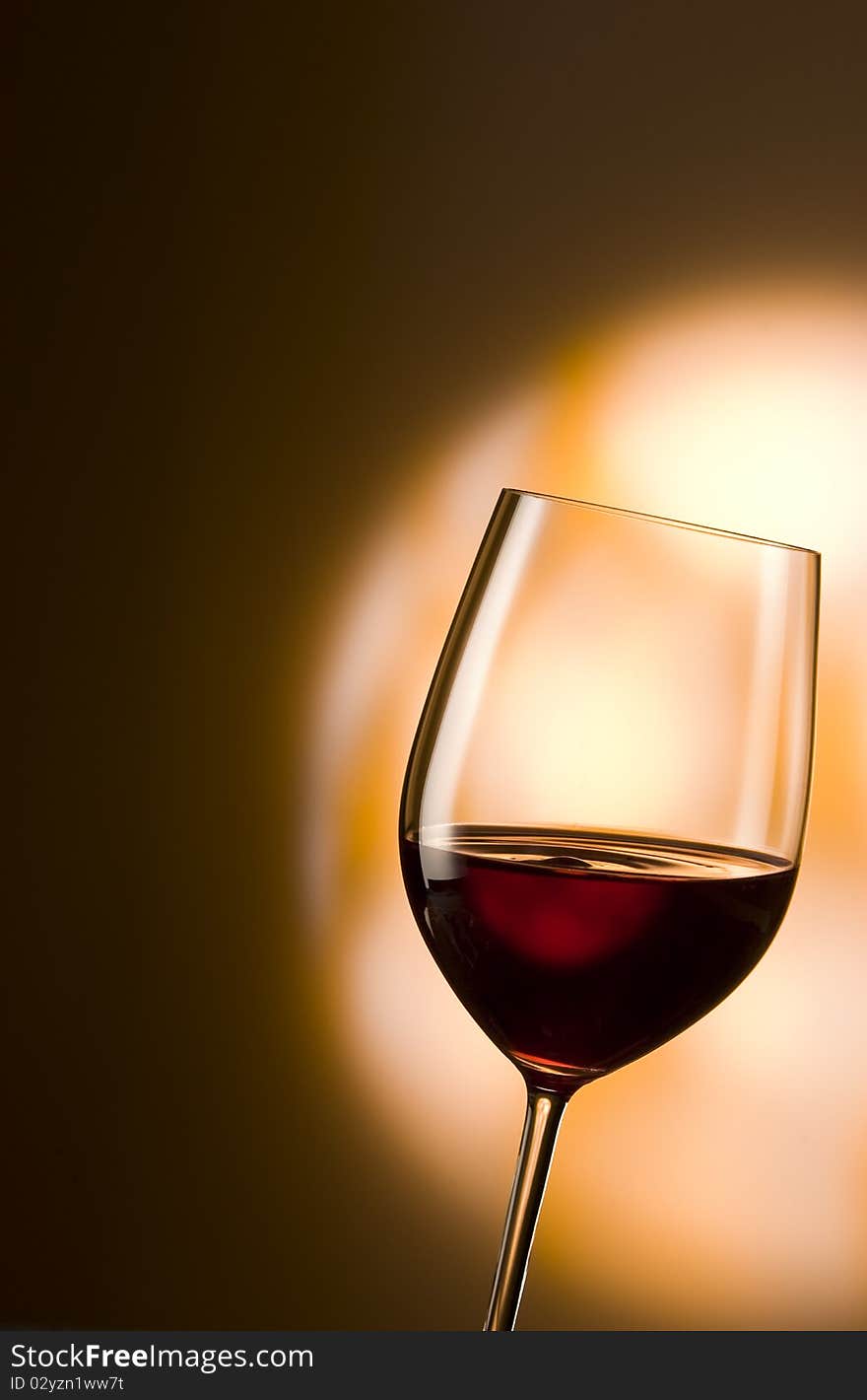 Glass of red wine in an orange spotlight