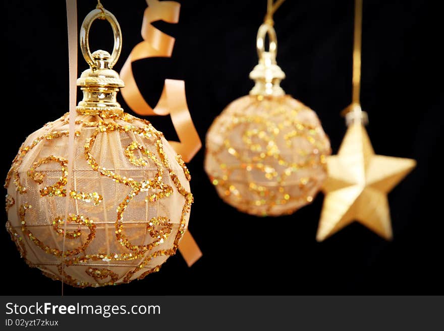 Golden Christmas balls and star on black background