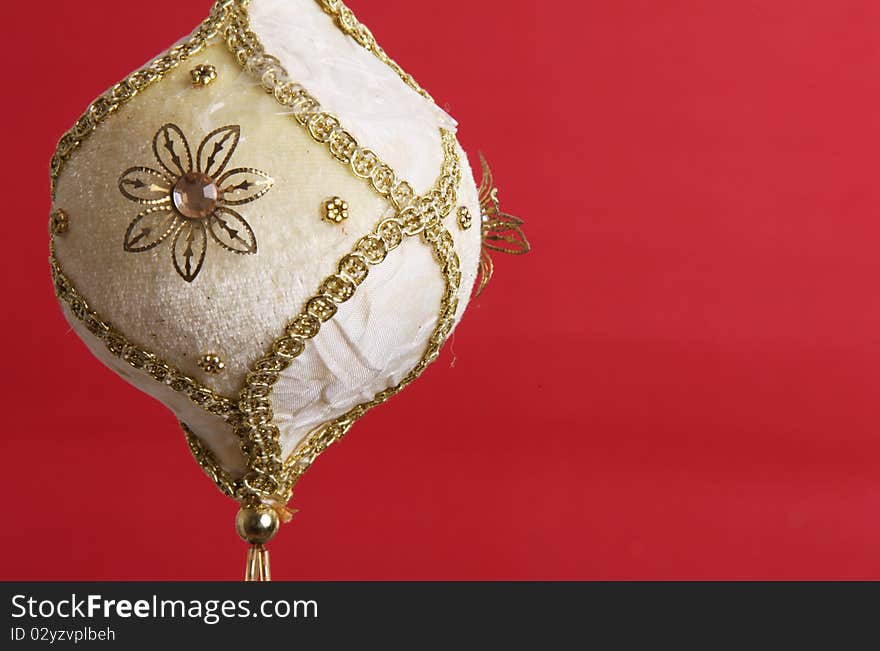 White and gold christmas ball on red background, space to add text or design