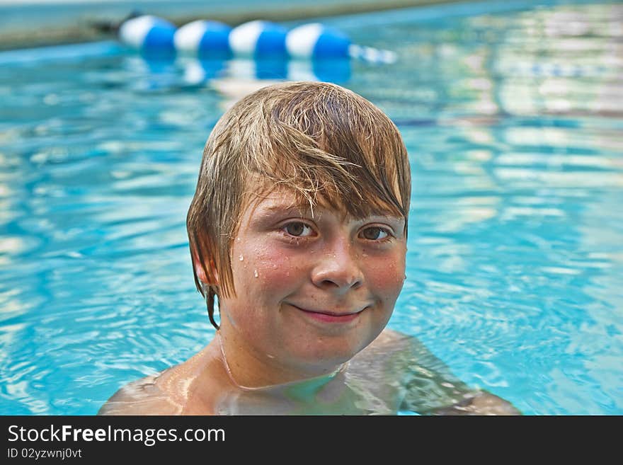 Boy enjoys swimming in an outdoor pool