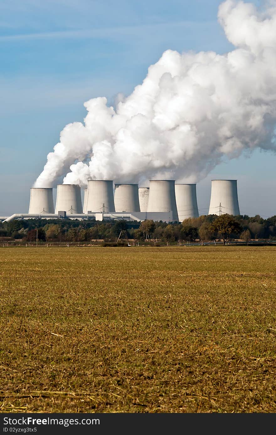 Cooling towers of a power plant with steam clouds and sky. Cooling towers of a power plant with steam clouds and sky