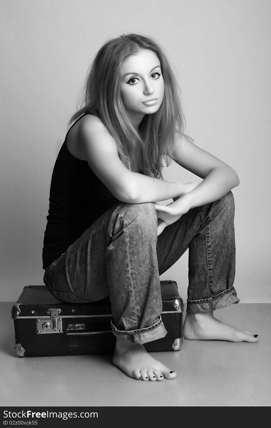 Portrait of a beautiful young woman with suitcase (black and white photography)