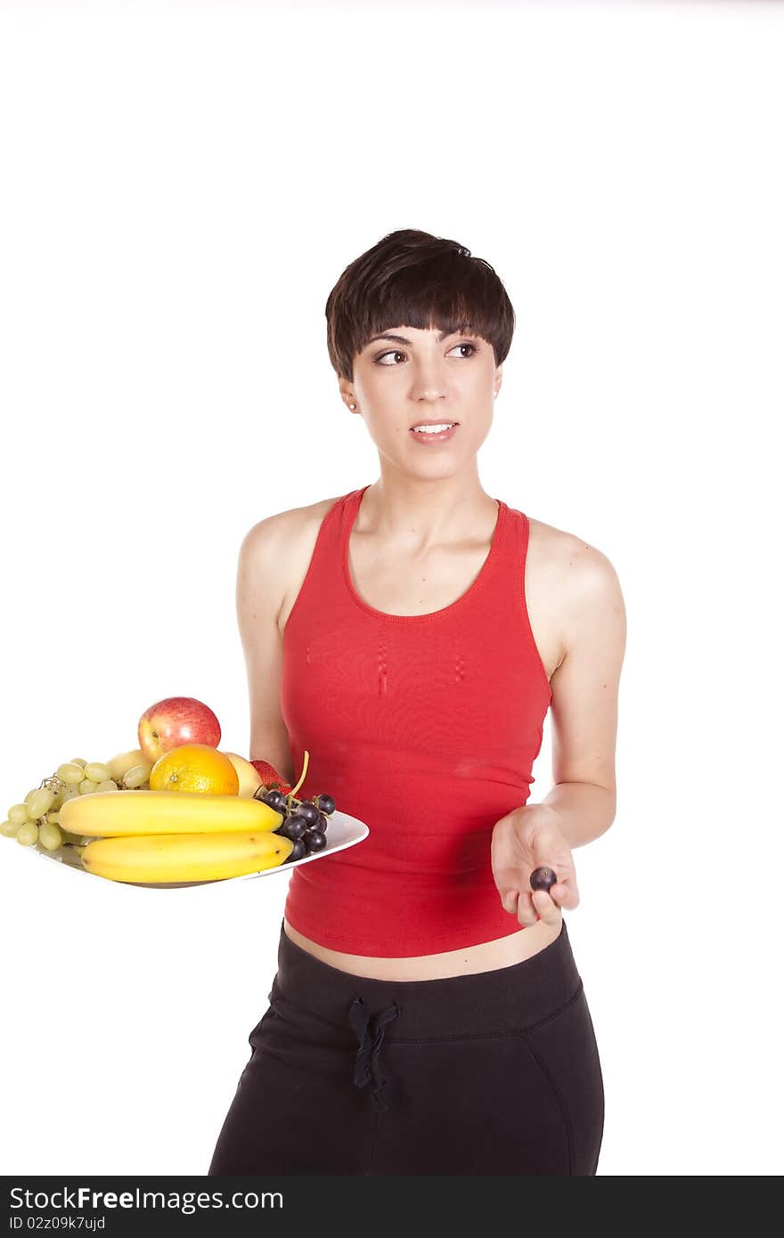 A woman holding out a plate of fresh fruit with a happy expression on her face. A woman holding out a plate of fresh fruit with a happy expression on her face.