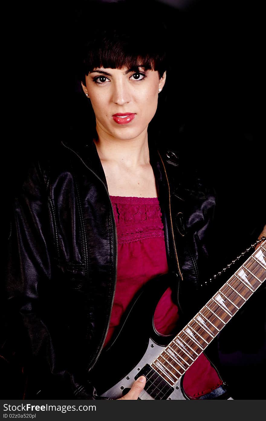 A woman with a expression on her face holding a guitar. A woman with a expression on her face holding a guitar.