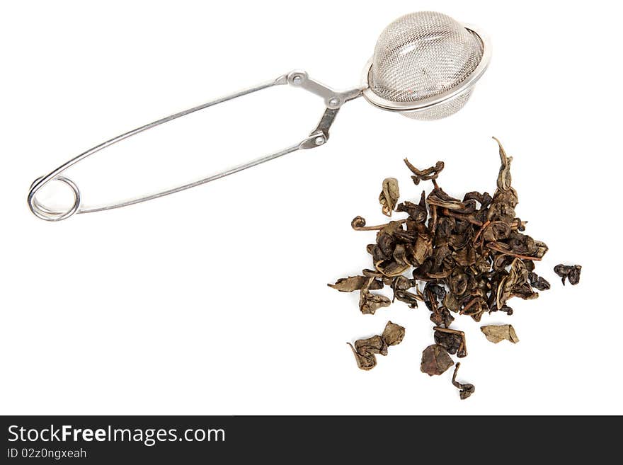 Dry green tea and strainer on white background