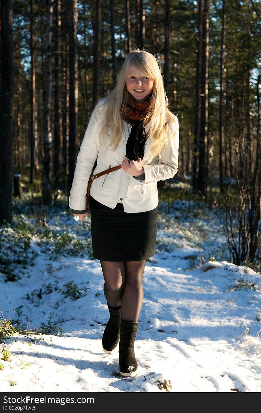 Young beautiful girl in white jacket on background wood