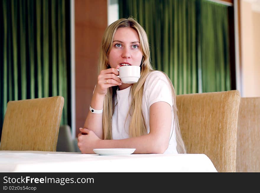 Happy woman in white with cup of coffee or tea. Happy woman in white with cup of coffee or tea.